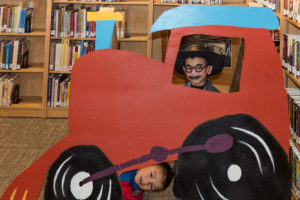 two children pose by a cardboard cutout train at the Love Your Library Day photo booth